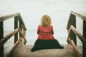 a woman sitting on a staircase looking out to the water