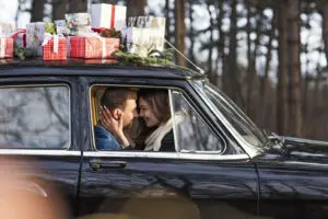 Couple in vintage car with gift of travel