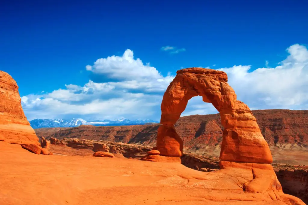 a rock formation in the desert with Arches National Park in the background