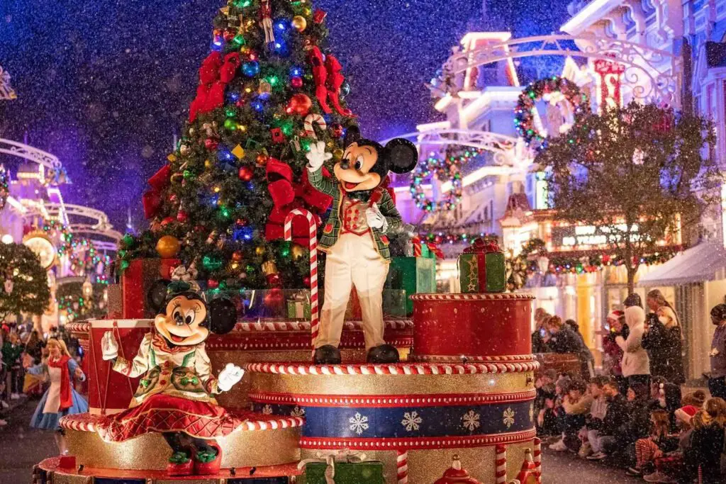 a mickey mouse and minnie mouse on a float with a christmas tree