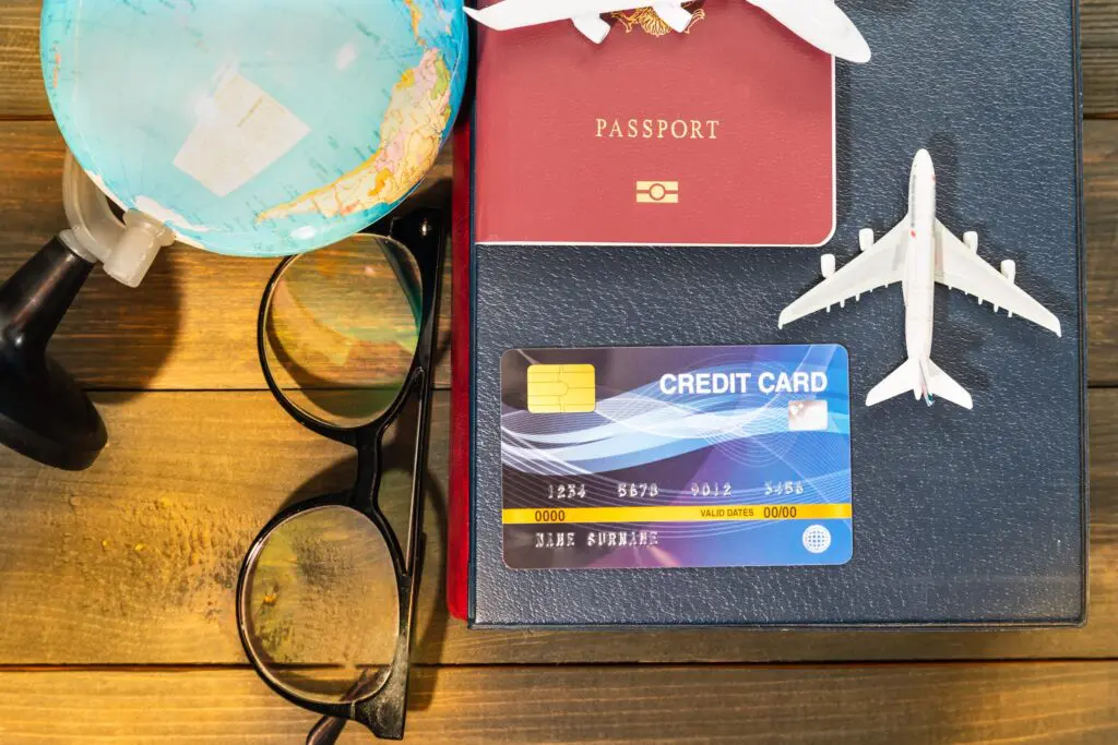 Credit card and airplane model on wooden table